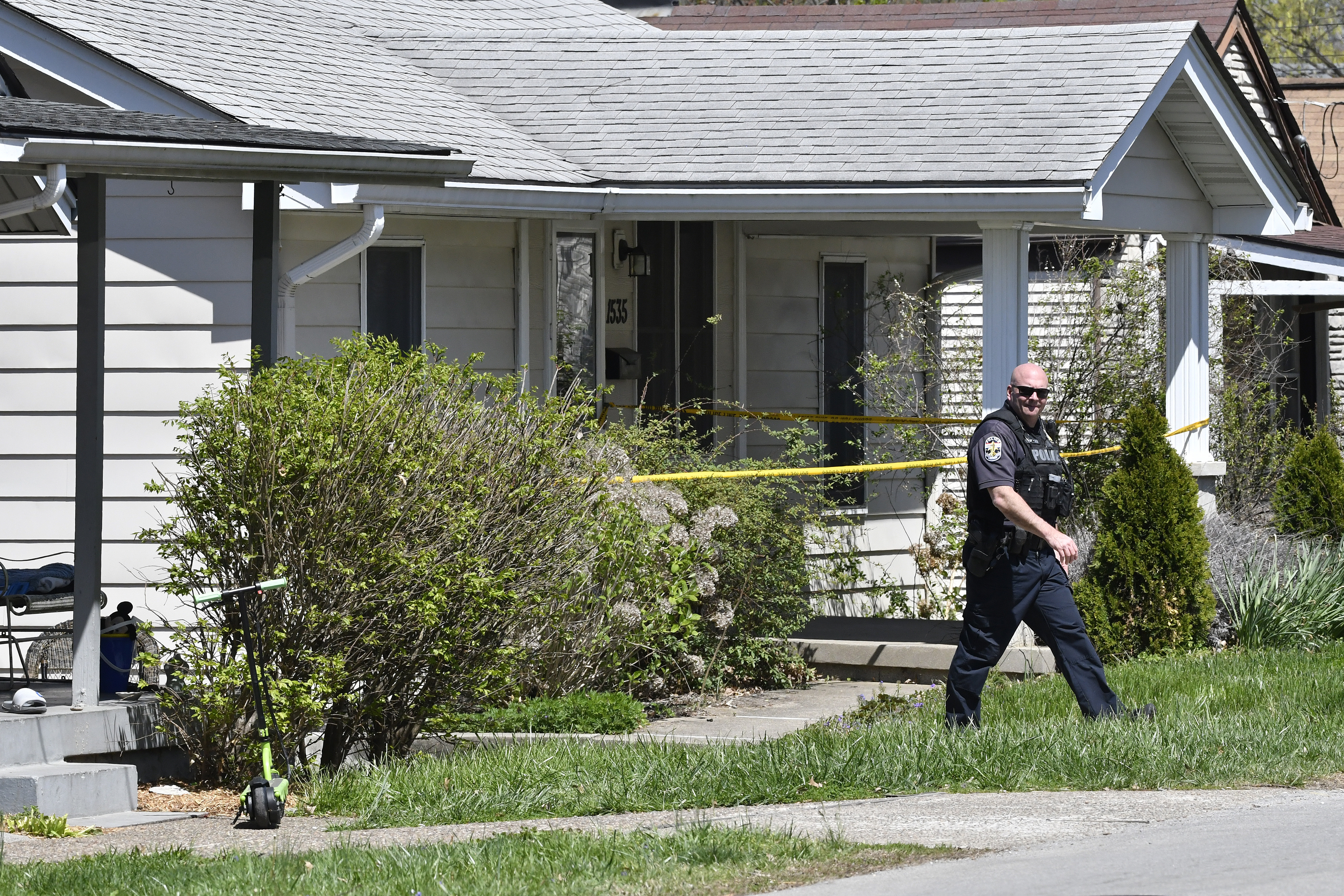 A Louisville Metro Police officer walks outside of the home of the suspected shooter in the Camp Taylor neighborhood in Louisville, Ky., Monday. Police say a 23-year-old armed with a rifle opened fire at his Louisville workplace, killing and wounding several, and was killed by police.