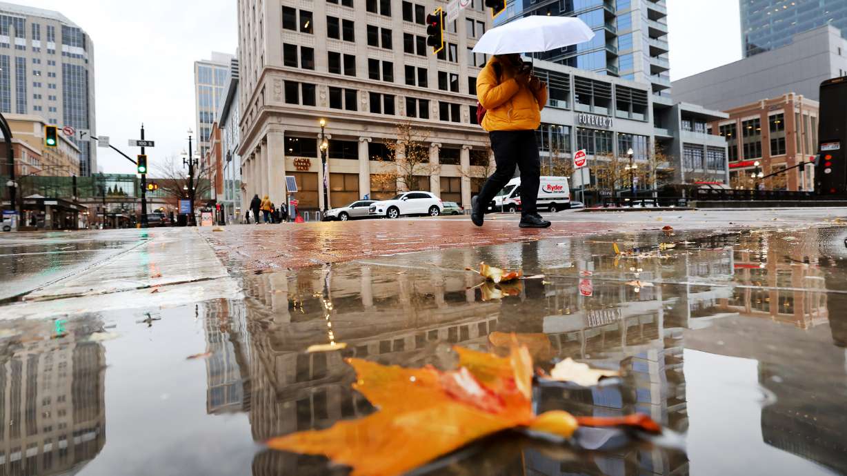 A pedestrian uses an umbrella to shield themselves from the rain in Salt Lake City on Dec. 27, 2022. Utah had its fifth-wettest first half of a water year since 1895, according to data released Monday.
