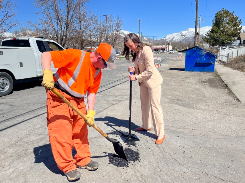 Salt Lake City Mayor Erin Mendenhall, right, uses a tamper to help a Salt Lake City Streets Division employee fill in potholes on Fremont Avenue in Salt Lake City Tuesday afternoon. Crews are slated to fix 6,000 potholes as a part a citywide event.