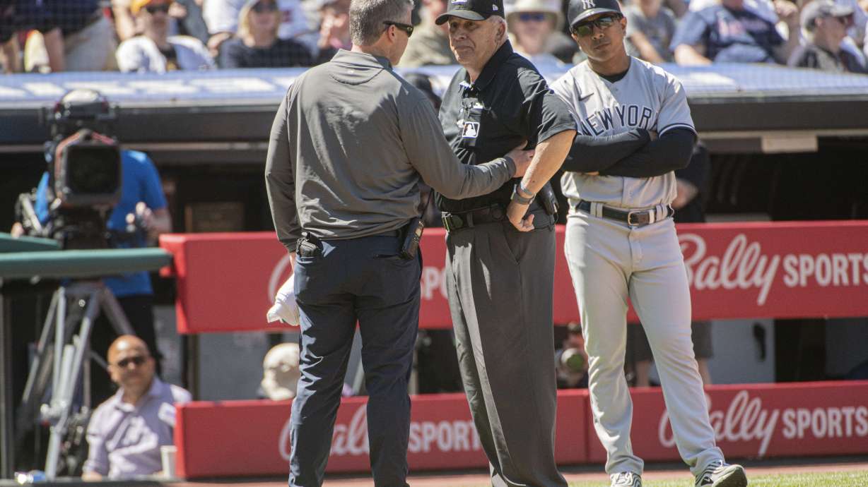 Umpire Larry Vanover is attended to by a Cleveland Guardians trainer after being hit by a throw from the outfield during the fifth inning of a baseball game in Cleveland, Wednesday April 12, 2023. Vanover left the game because of the injury.