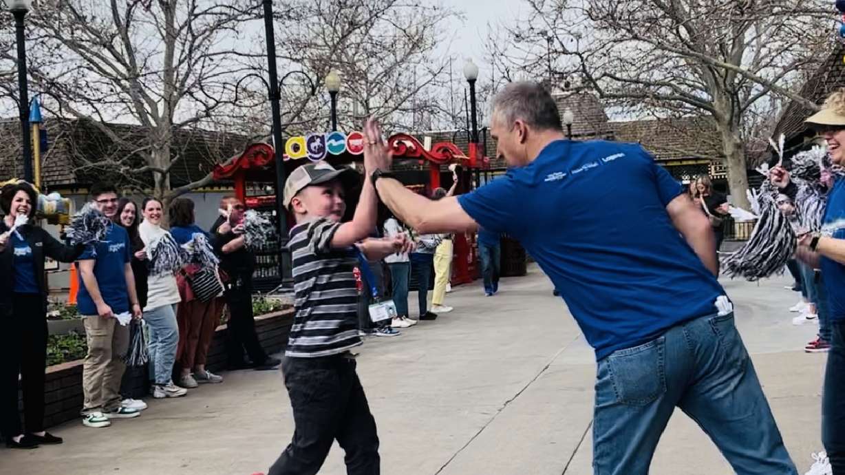 Logan Knapp gives a high five at Lagoon, which was aptly named Loganland for the day on Wednesday.