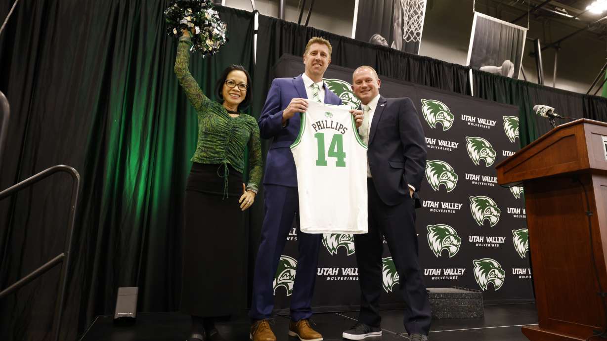 Utah Valley men's basketball coach Todd Phillips with athletic director Jared Sumsion and UVU president Astrid Tuminez, left, after being introduced as the program's fourth head coach in its Division I era, Wednesday, April 12, 2023 at the NUVI practice facility in Orem, Utah.