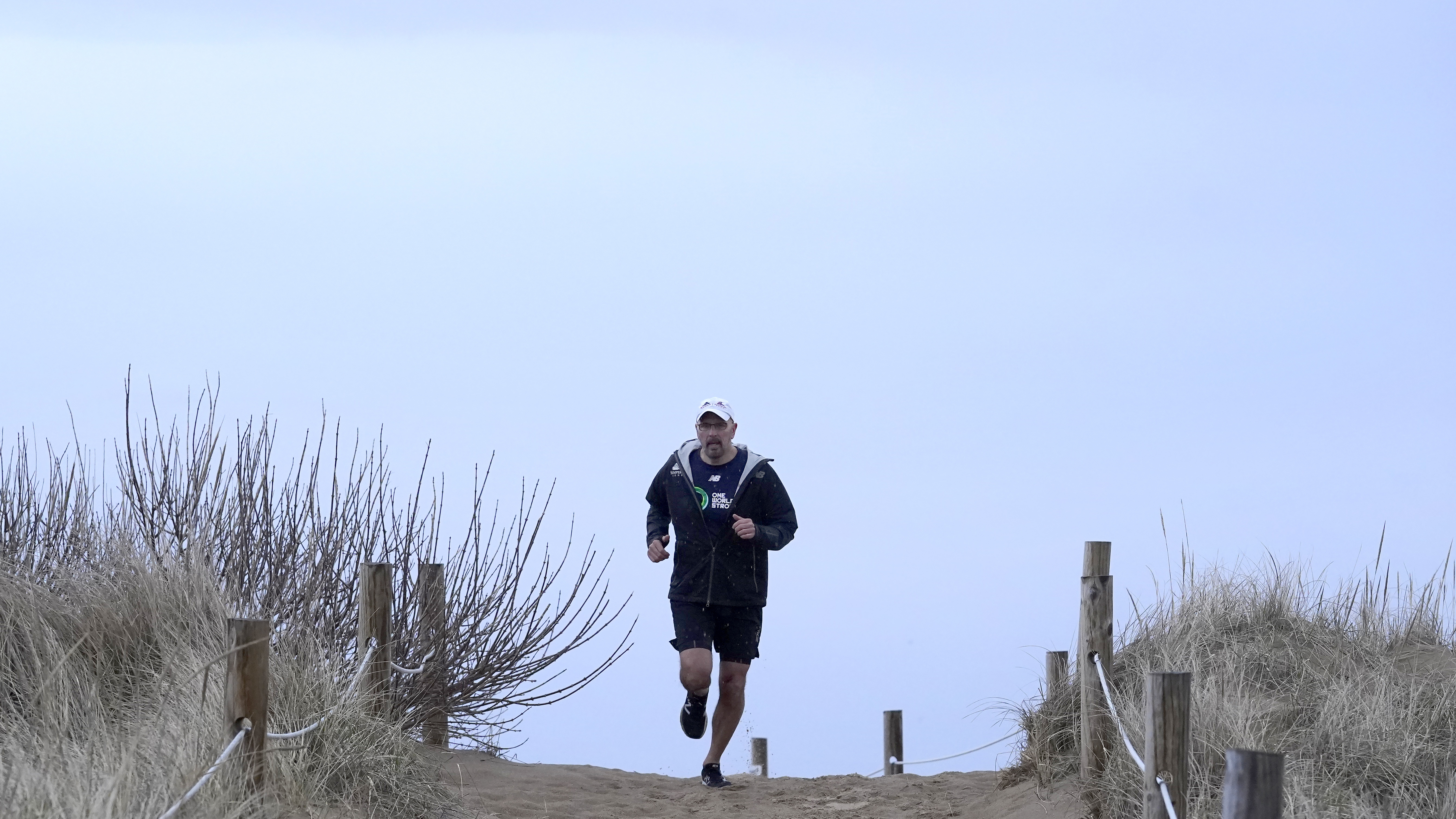 Dave Fortier, of Newburyport, Mass., president of One World Strong Foundation, trains for the 2023 Boston Marathon as he runs along a path to a beach Tuesday, April 4, 2023, in Newburyport. Fortier was hit in the foot by shrapnel in the 2013 bombing and doesn't remember finishing the race. 