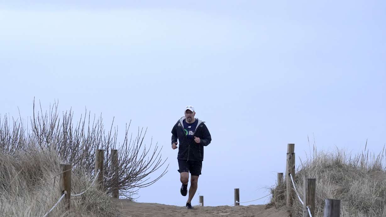 Dave Fortier, of Newburyport, Mass., president of One World Strong Foundation, trains for the 2023 Boston Marathon as he runs along a path to a beach Tuesday, April 4, 2023, in Newburyport. Fortier was hit in the foot by shrapnel in the 2013 bombing and doesn't remember finishing the race.