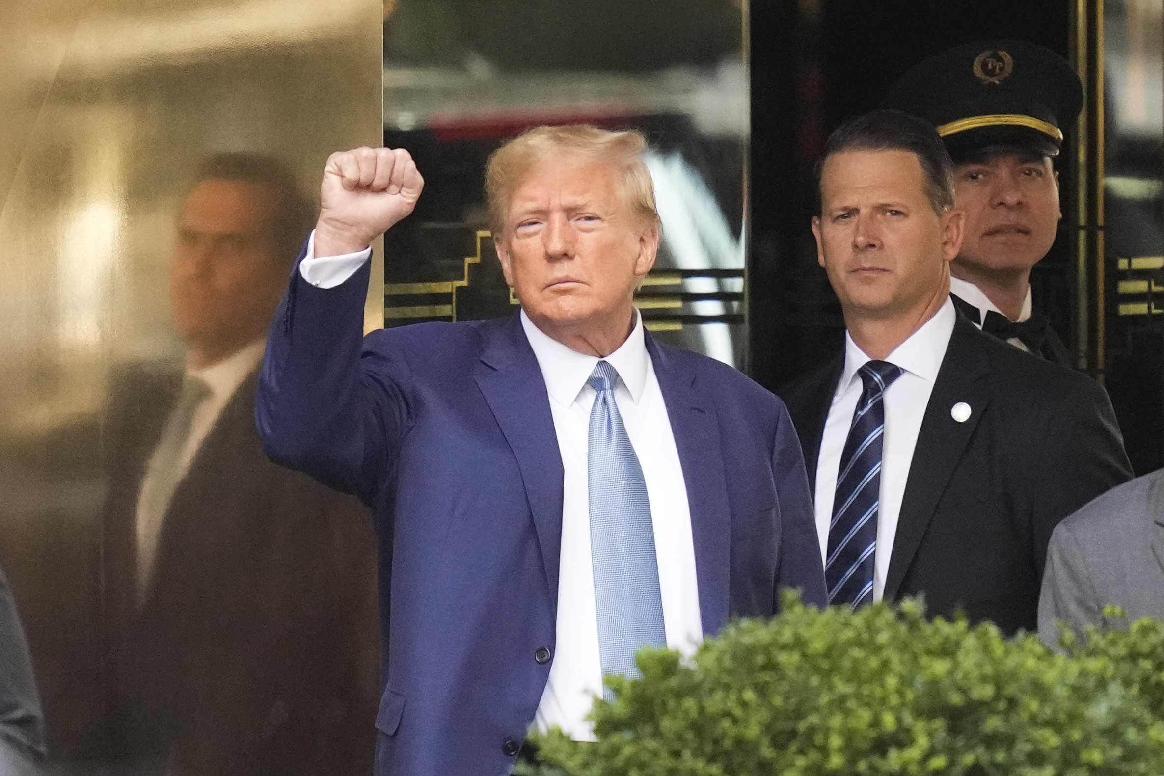 Former President Donald Trump, left, gestures as he leaves Trump Tower in New York City on Thursday. Trump answered questions for hours during his second deposition in a legal battle with New York's attorney general over business practices.