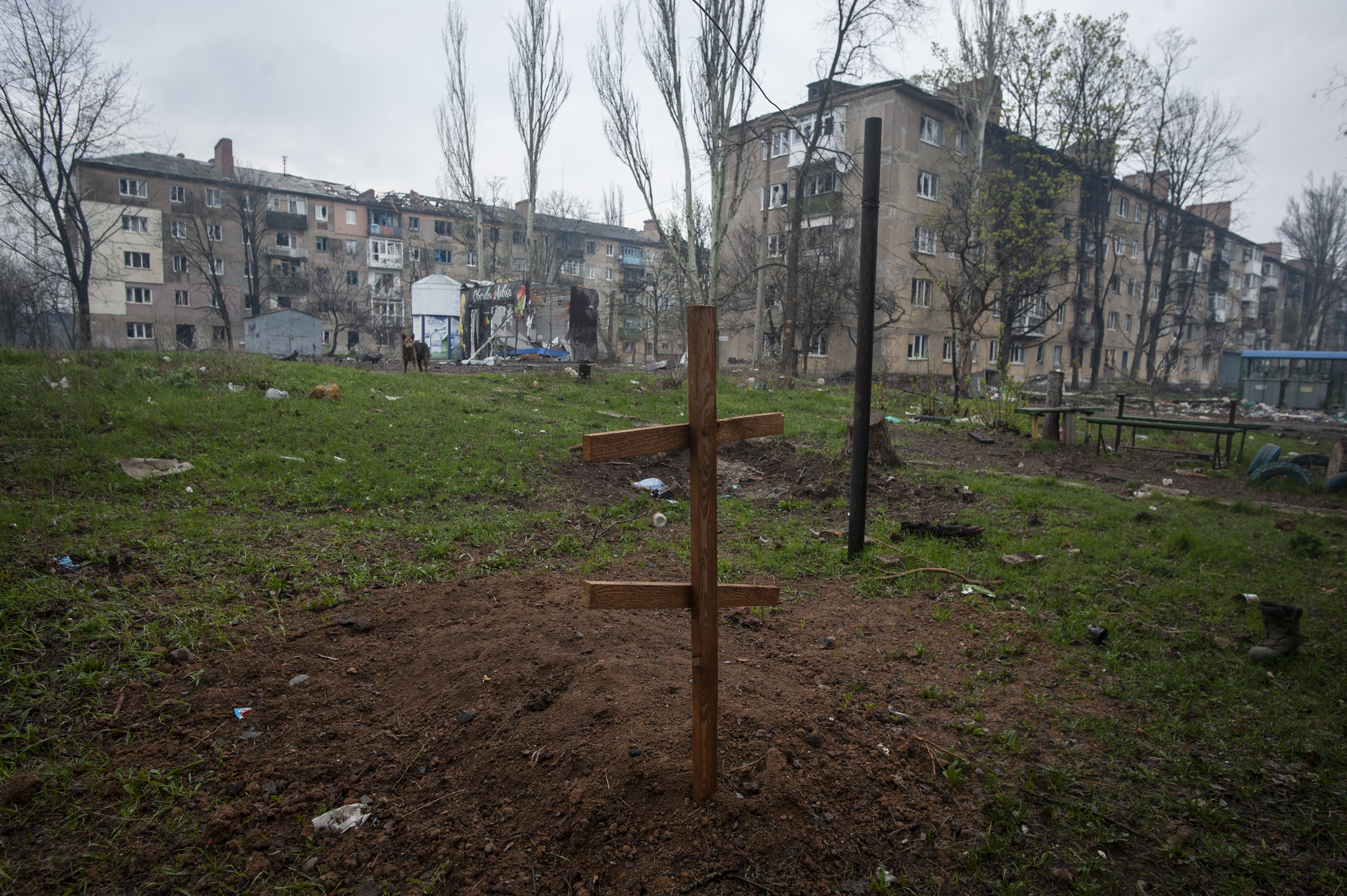 A cross on the grave of a local resident killed by Russian shelling, in the yard of an apartment building in war-hit Bakhmut, Donetsk region, Ukraine, Wednesday. FBI agents converged Thursday at the home of an Air National Guard member who is a main person of interest in the disclosure of highly classified military documents on the Ukraine war.
