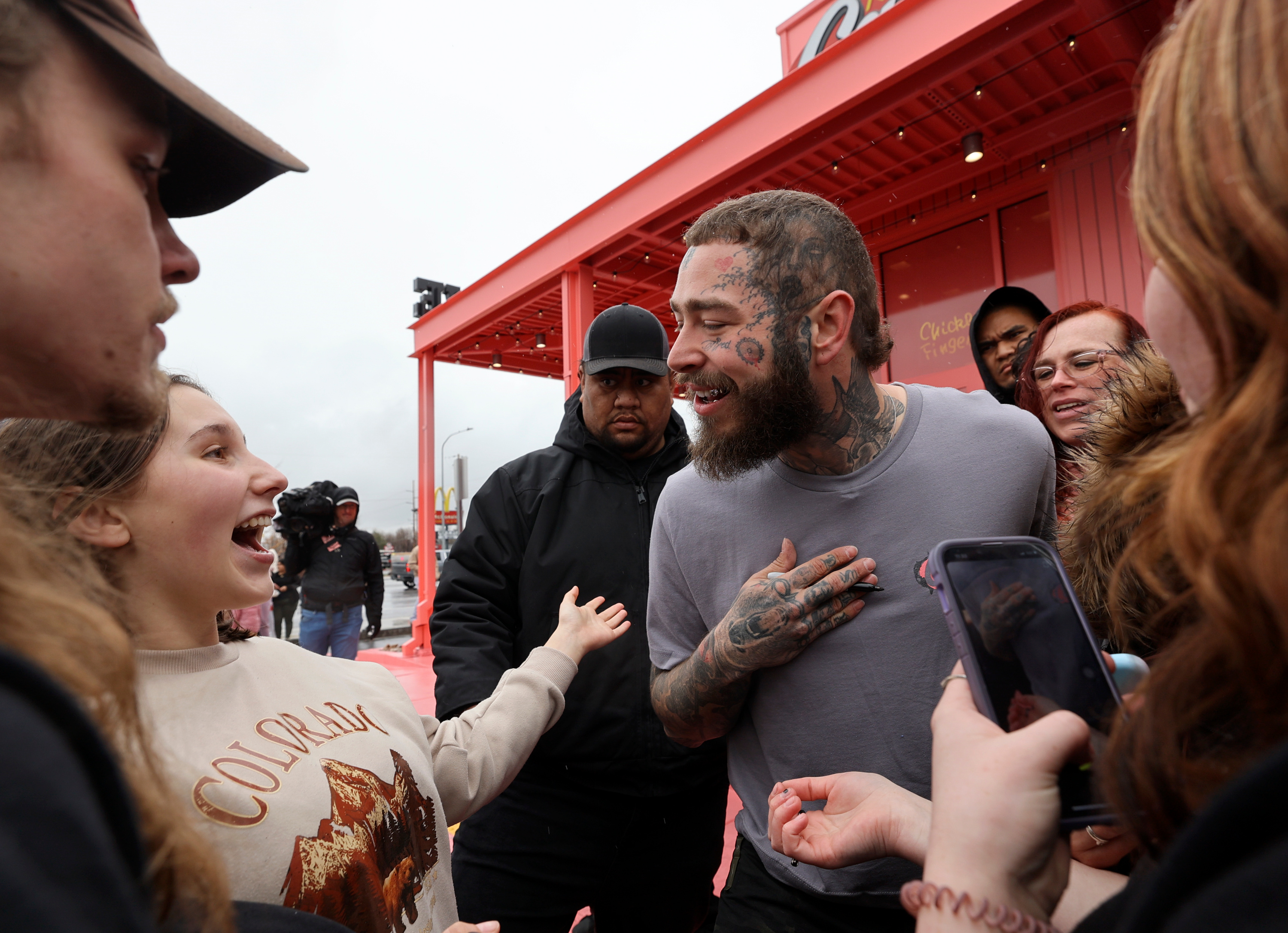 Fans talk to Post Malone during the grand opening celebration of a Raising Cane’s Restaurant, designed by Post Malone, in Midvale on Thursday.
