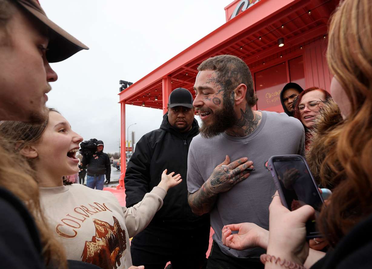 Fans talk to Post Malone during the grand opening celebration of a Raising Cane’s Restaurant, designed by Post Malone, in Midvale on Thursday.