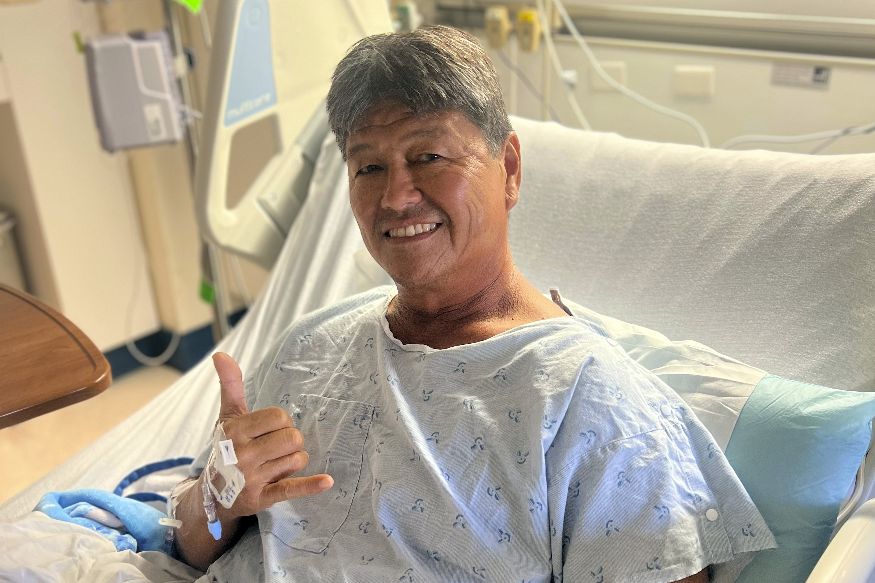 Mike Morita poses for a photo from his hospital bed, Wednesday, April 10, 2023, in Honolulu. Morita credits a faith in God for surviving an Easter Sunday shark attack and for remaining at peace despite losing his right foot. 