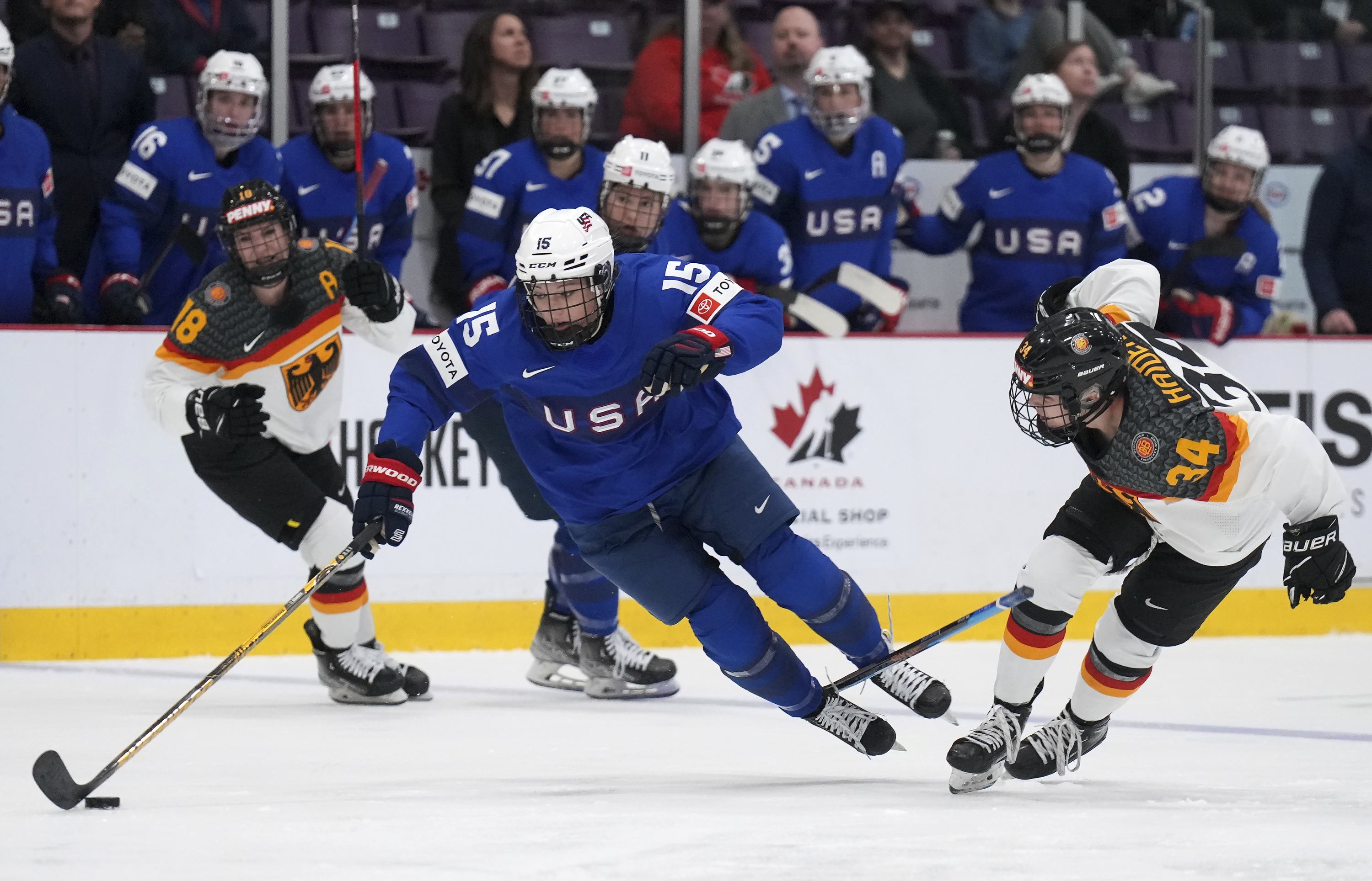 Germany forward Celina Haider (34) trips up USA defender Savannah Harmon (15) during the second period of a quarterfinal match at the Women's World Hockey Championships in Brampton, Ontario, Thursday, April 13, 2023. 