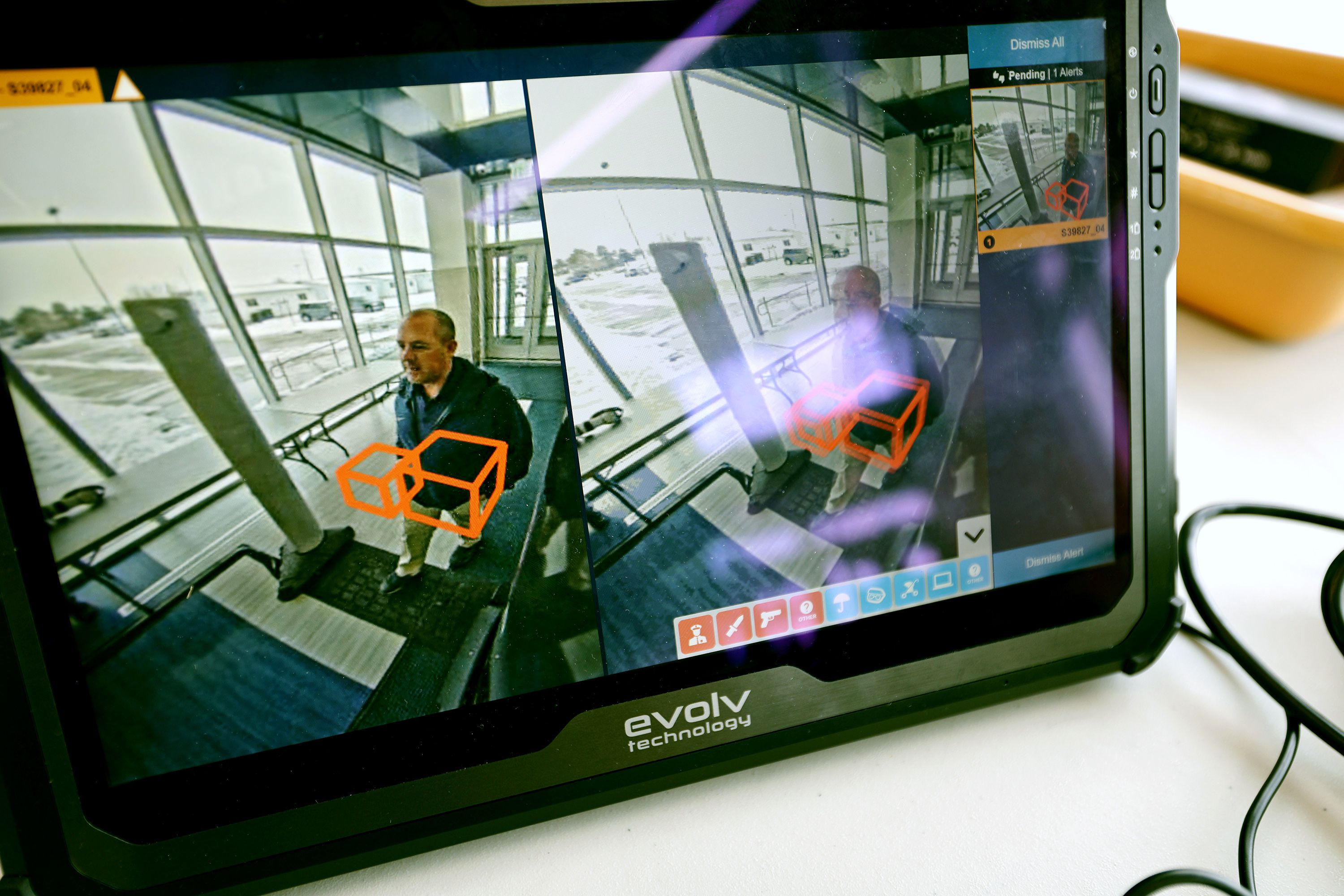 Tysen Fausett, assistant principal at Hunter High School, walks through the scanners as he demonstrates their effectiveness. The school is piloting a new technology that is helping to keep them safer on April 4.