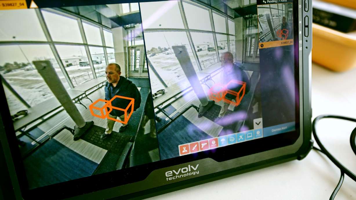 Tysen Fausett, assistant principal at Hunter High School, walks through the scanners as he demonstrates their effectiveness. The school is piloting a new technology that is helping to keep them safer on April 4.