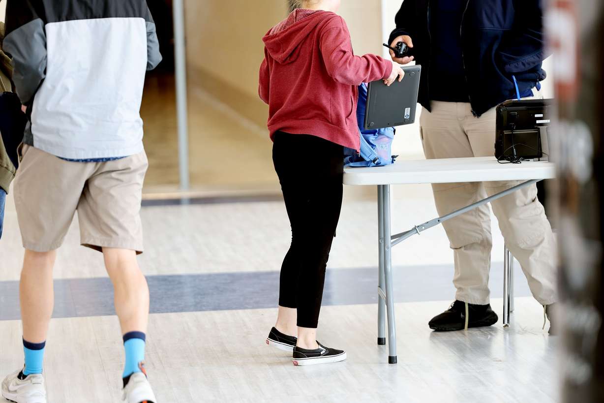 A Hunter High School student replaces their computer after walking through the scanners on April 4. The West Valley City school is piloting a new technology that is helping to keep the school safer.