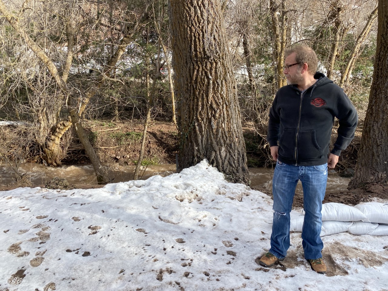 Tim Erickson says water from Emigration Creek backed up near his home Tuesday, flooding his yard and flowing over the driveway.