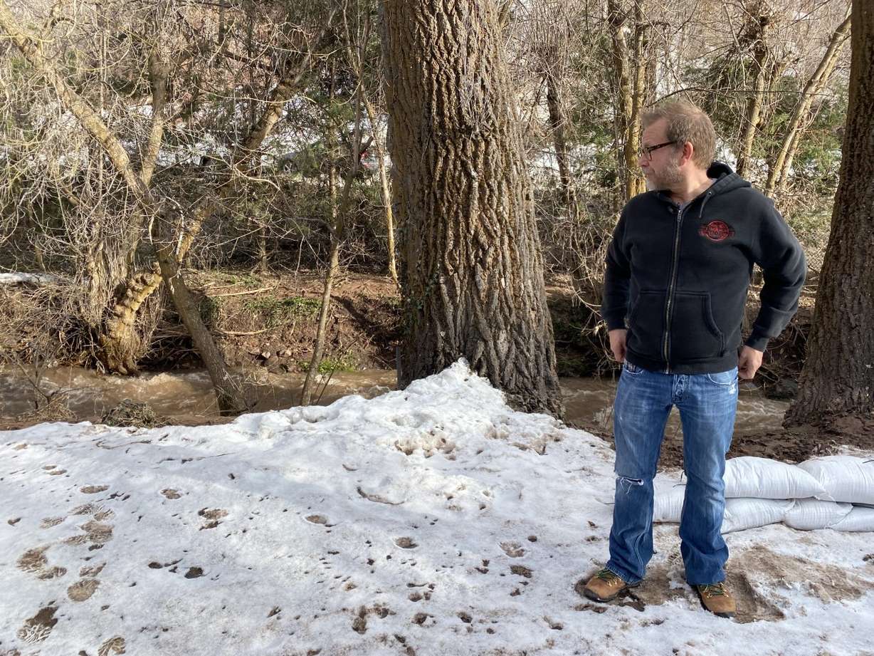 Tim Erickson says water from Emigration Creek backed up near his home Tuesday, flooding his yard and flowing over the driveway.