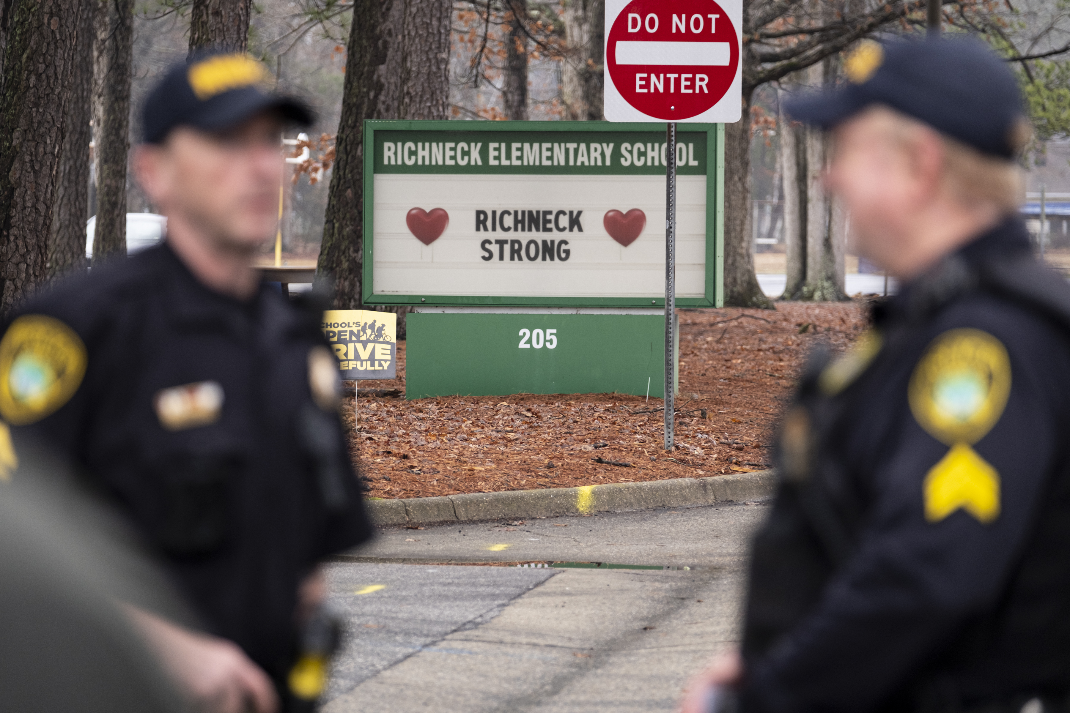 Police look on as students return to Richneck Elementary on Jan. 30, in Newport News, Va. The mother of a 6-year-old Virginia boy who shot and wounded his teacher at Richneck Elementary had a series of miscarriages and post-partum depression in the year before the shooting, her attorney said Friday.