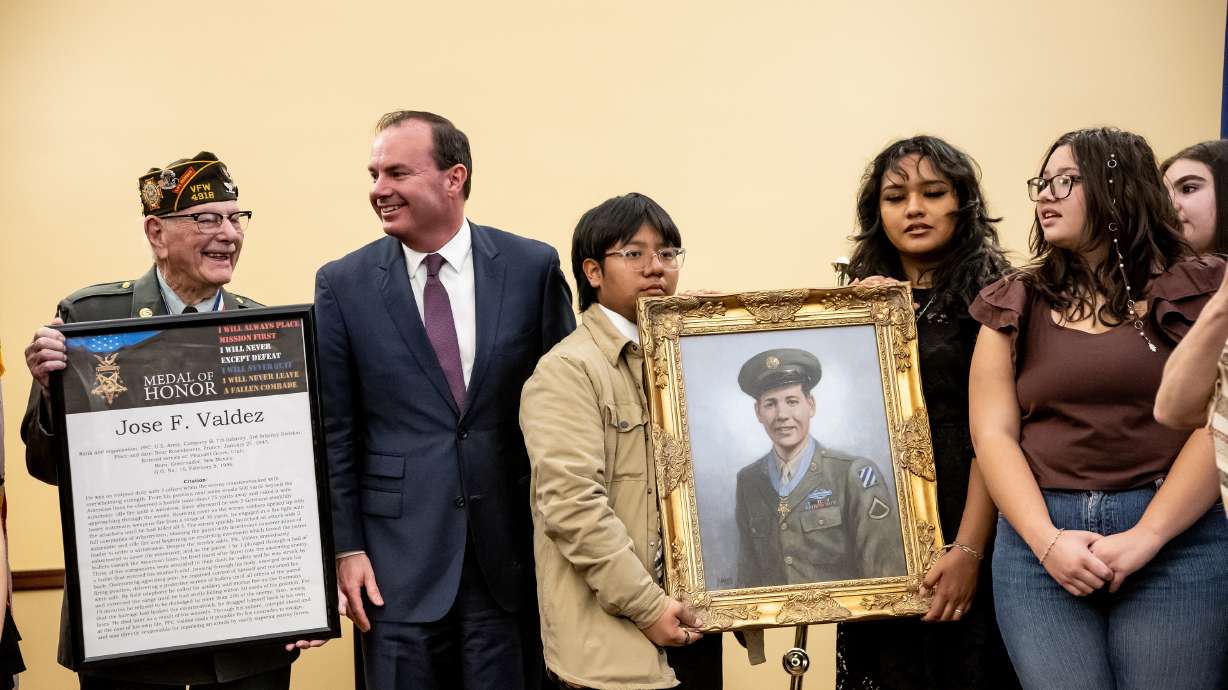 World War II and Korean War veteran Robert T. Bates and Sen. Mike Lee, R-Utah, stand with Orem High Latinos in Action holding a painting of Jose F. Valdez, Utah’s only Hispanic Medal of Honor recipient, at the state Capitol in Salt Lake City Friday.