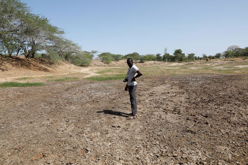 Famine Early Warning System Network in Africa scientist Chris Shitote examines a dry water hole in Kilifi county, Kenya, on Feb. 16, 2022. Africa needs more help from international institutions and wealthy nations to cope with its struggles, African finance ministers said on Saturday.