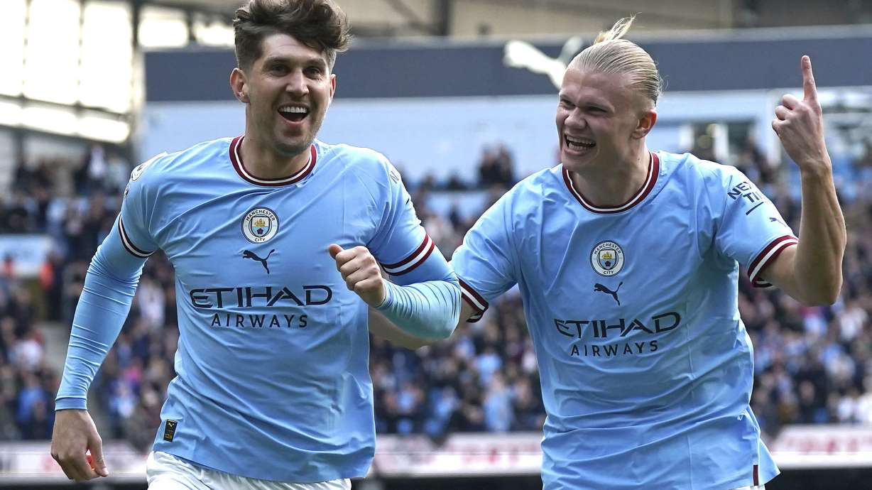 Manchester City's John Stones, left, celebrates with teammate Erling Haaland after scoring his side's opening goal during the English Premier League soccer match between Manchester City and Leicester City at Etihad Stadium in Manchester, England, Saturday, April 15, 2023.