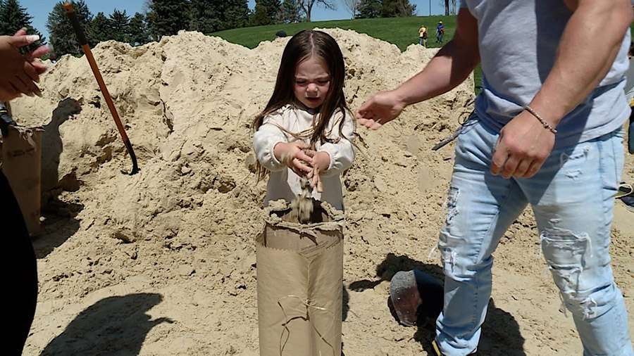 Braeya Allred, a young volunteer, fills up a sandbag at Sugar House Park. The Allred family is part of hundreds of people who spent Saturday morning filling sandbags at several volunteer sites throughout Utah.