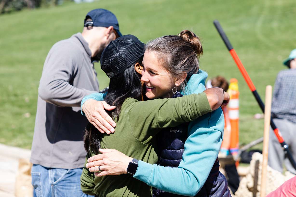 Salt Lake City Mayor Erin Mendenhall hugs a volunteer as they work to fill up sandbags at Sugar House Park in Salt Lake City on Saturday.