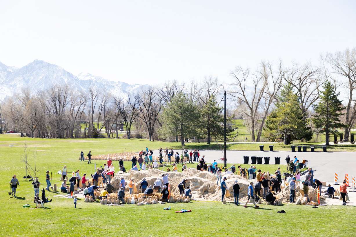 Volunteers fill up sandbags at Sugar House Park in Salt Lake City on Saturday.
