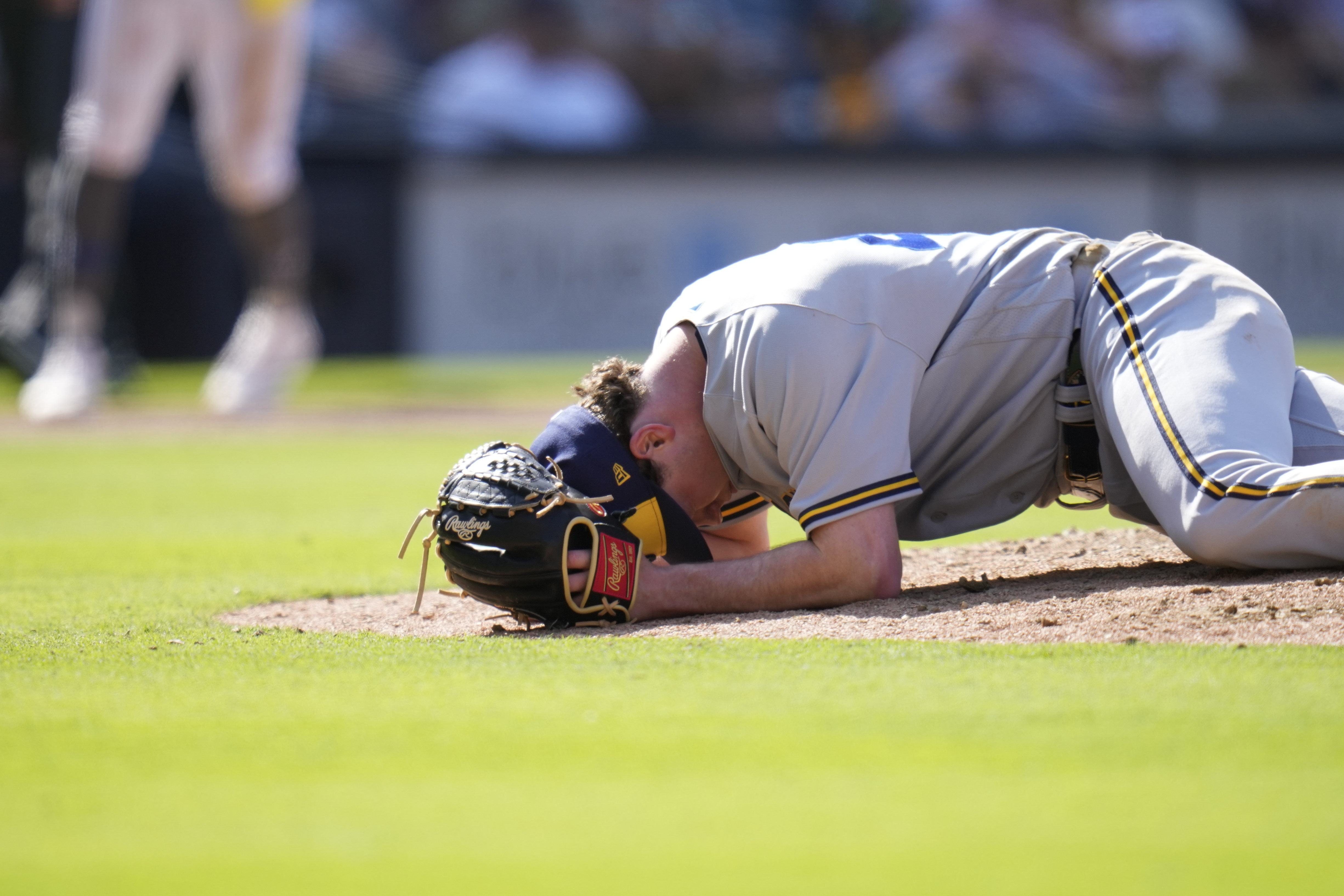 Milwaukee Brewers relief pitcher Gus Varland reacts after being hit by a comebacker from San Diego Padres' Manny Machado during the eighth inning of a baseball game Saturday, April 15, 2023, in San Diego. 