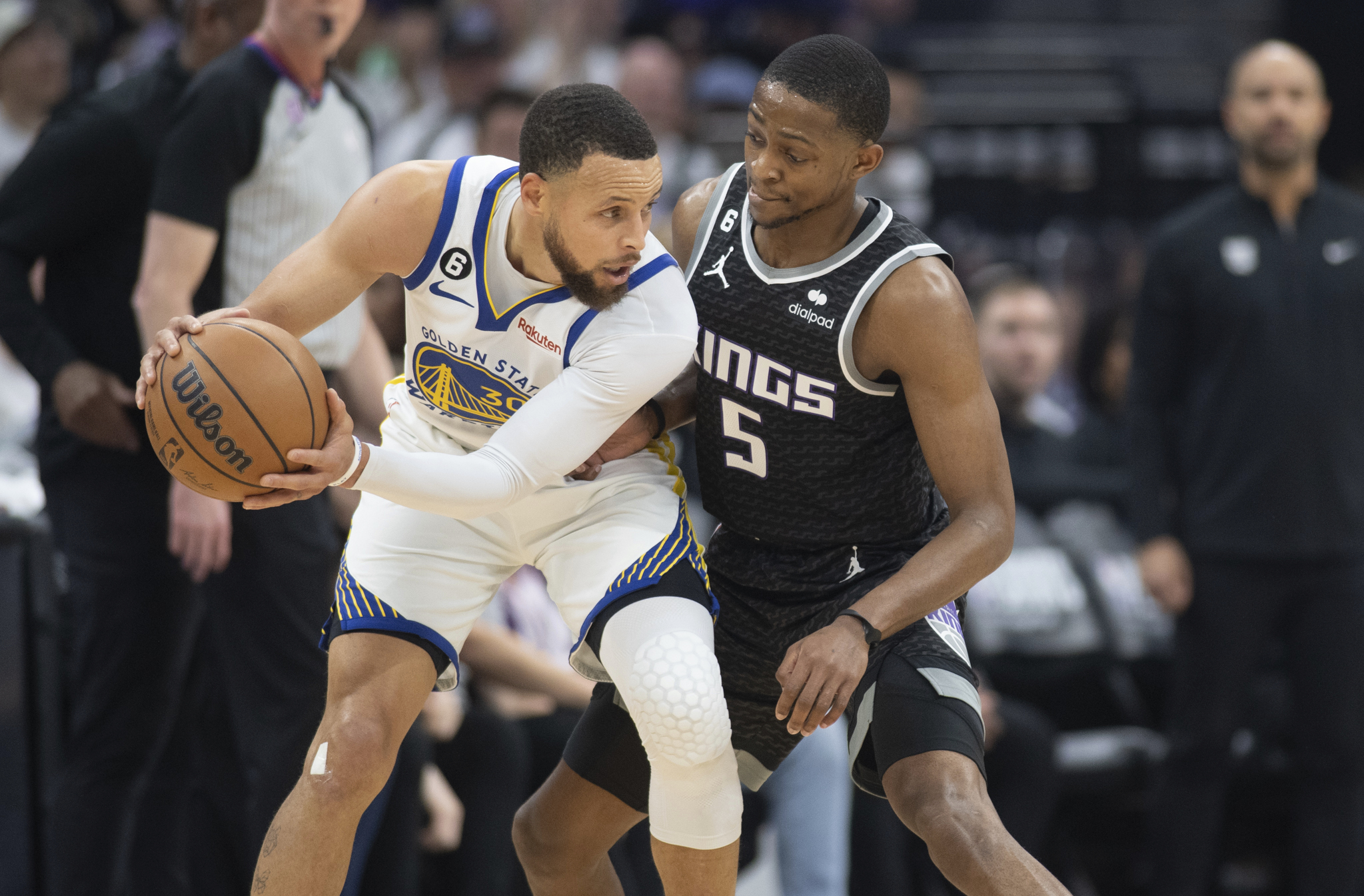 Golden State Warriors guard Stephen Curry (30) looks to pass against Sacramento Kings guard De'Aaron Fox (5) in the first quarter during Game 1 in the first round of the NBA basketball playoffs in Sacramento, Calif., Saturday, April 15, 2023. 