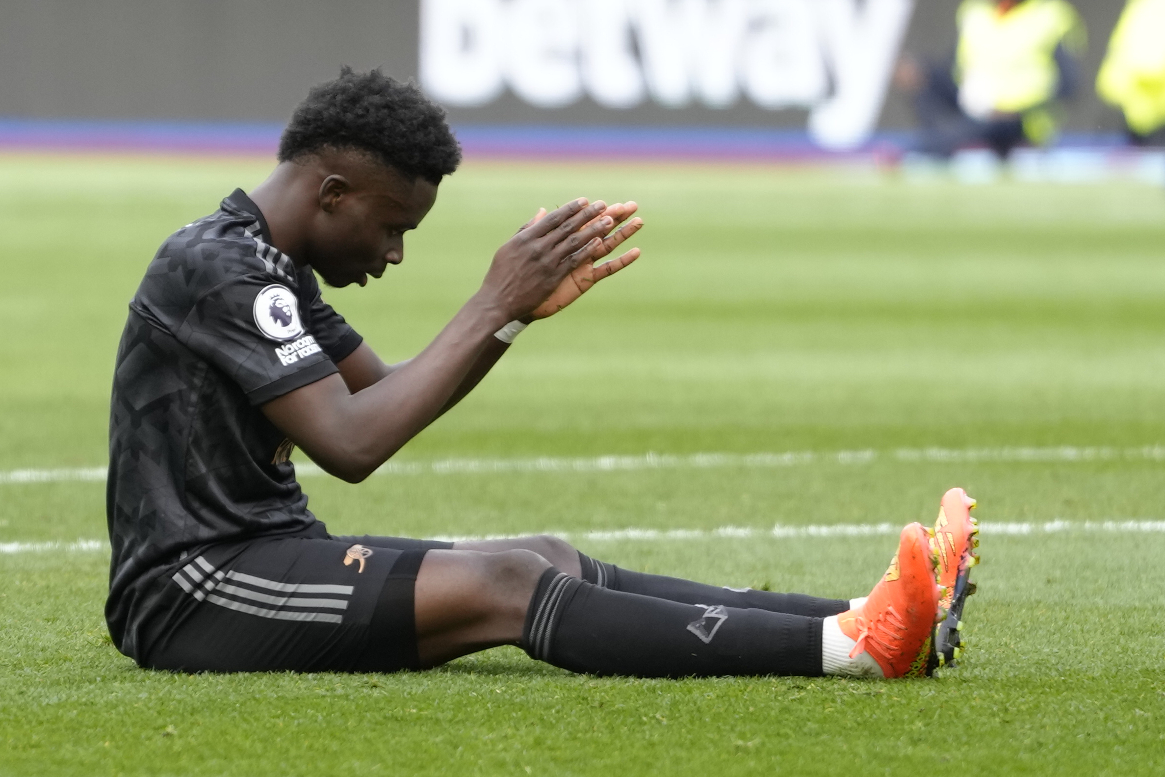 Arsenal's Bukayo Saka reacts after missing a penalty kick during the English Premier League soccer match between West Ham United and Arsenal at the London stadium in London, Sunday, April 16, 2023. 