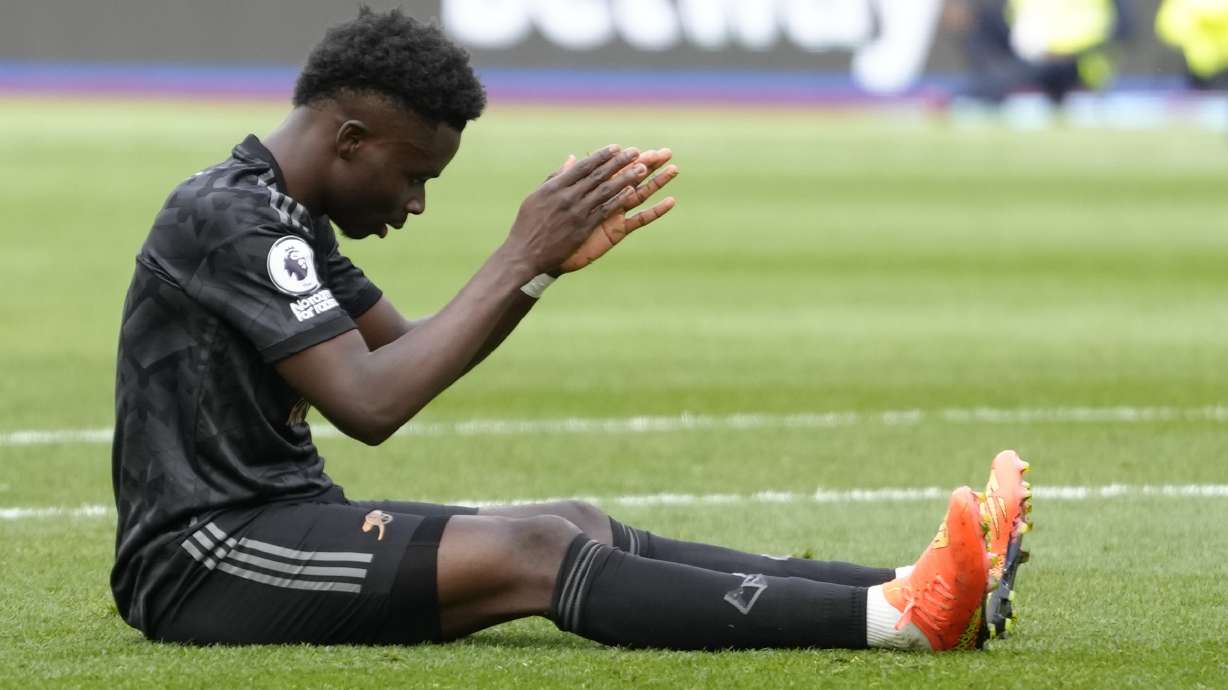 Arsenal's Bukayo Saka reacts after missing a penalty kick during the English Premier League soccer match between West Ham United and Arsenal at the London stadium in London, Sunday, April 16, 2023.