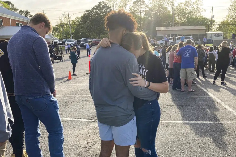 Two teens embrace at a prayer vigil on Sunday, outside First Baptist Church in Dadeville, Ala. Several people were killed and over two dozen were injured in a shooting at a teen birthday party in the town on Saturday.