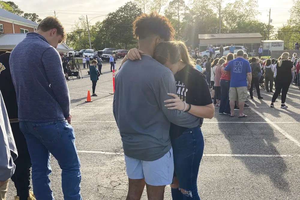 Two teens embrace at a prayer vigil on Sunday, outside First Baptist Church in Dadeville, Ala. Several people were killed and over two dozen were injured in a shooting at a teen birthday party in the town on Saturday.