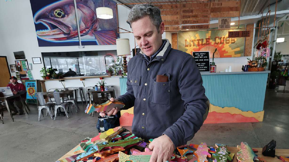 Artist Chris Peterson looks over painted fish at the Neighborhood Hive in Sugar House on April 4. Peterson is overseeing an art contest for the Utah Wildlife Federation.