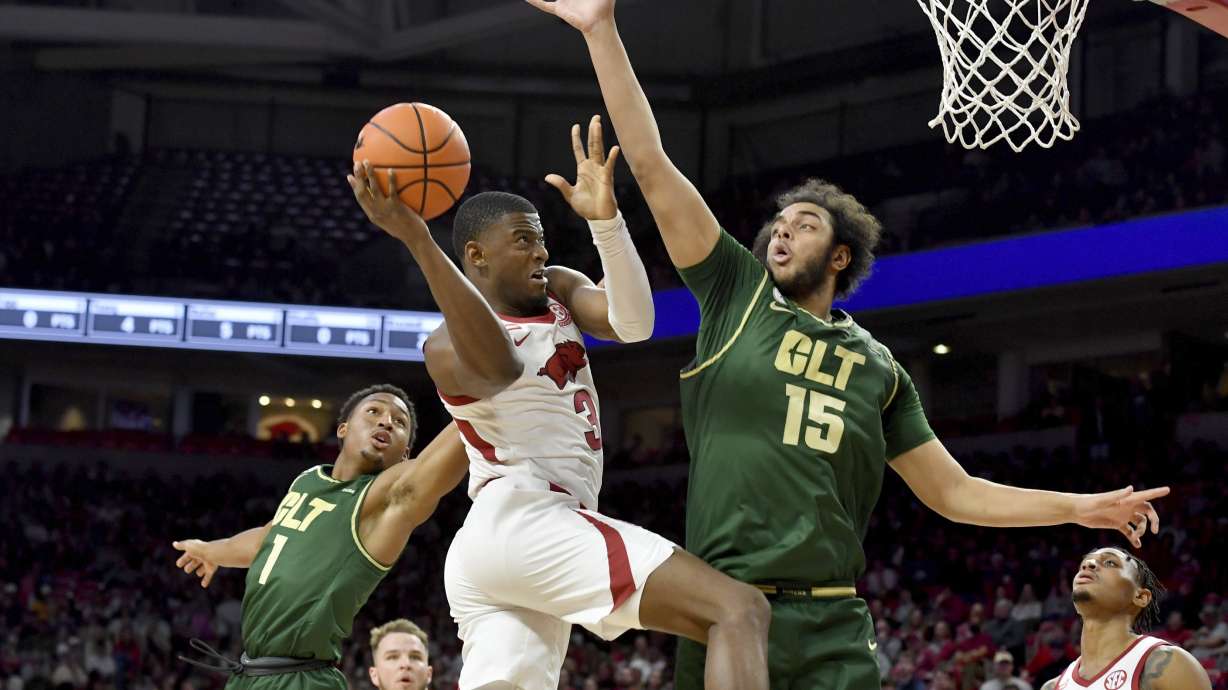 Arkansas forward Trey Wade (3) tries to shoot over Charlotte defenders Jahmir Young (1) and Aly Khalifa (15) during the first half of an NCAA college basketball game Tuesday, Dec. 7, 2021, in Fayetteville, Ark.