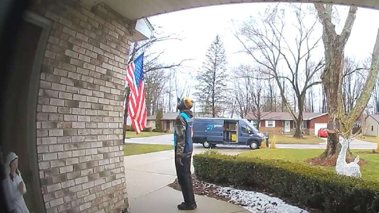 An Amazon driver salutes the American flag after delivering a package in Michigan.