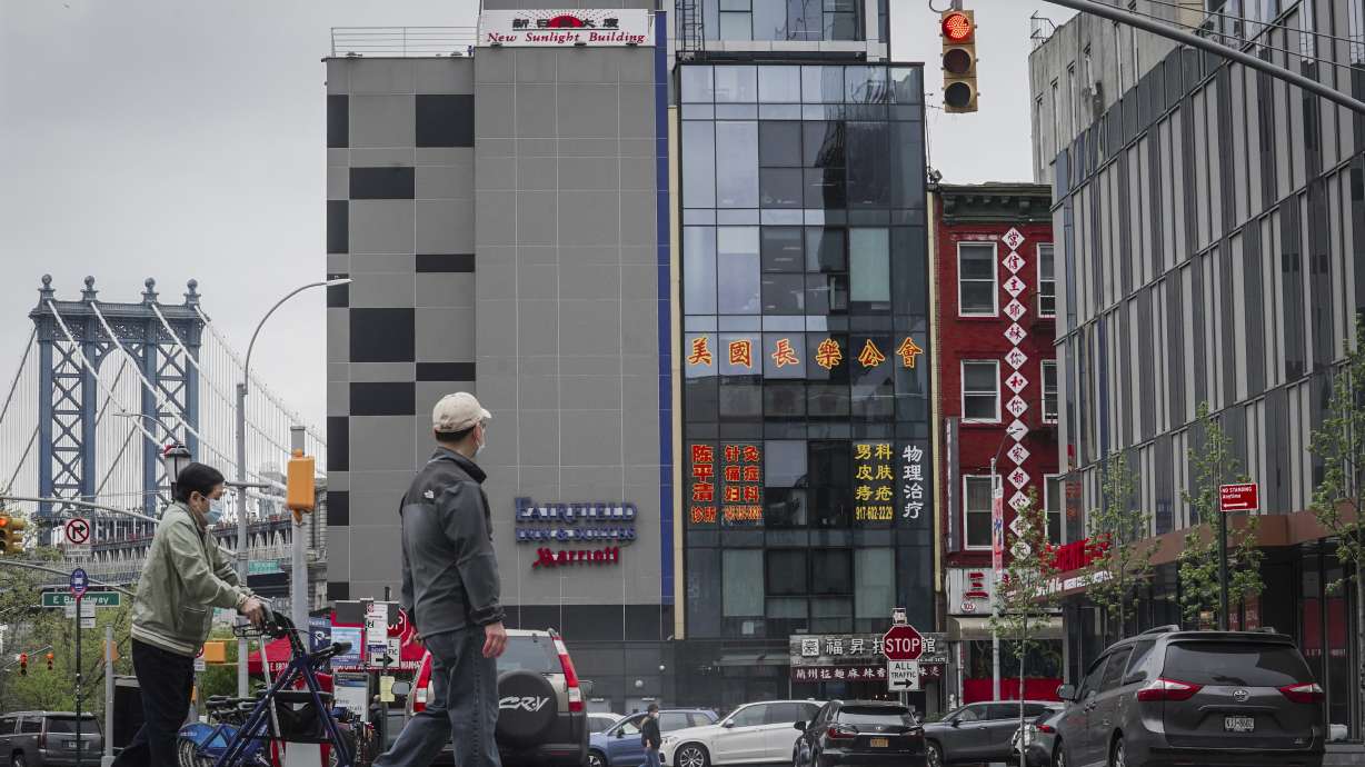 A six-story glass facade building, center, is believed to be the site of a foreign police outpost for China in New York, Monday. Justice Department officials say two men have been arrested on charges they helped establish a secret police outpost on behalf of the Chinese government.