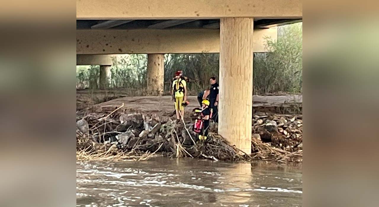 Emergency personnel rescue two juveniles stranded in a pile of debris more than 20 feet from the shore of the Virgin River near Mall Drive and Dinosaur Crossing area of St. George, Sunday.