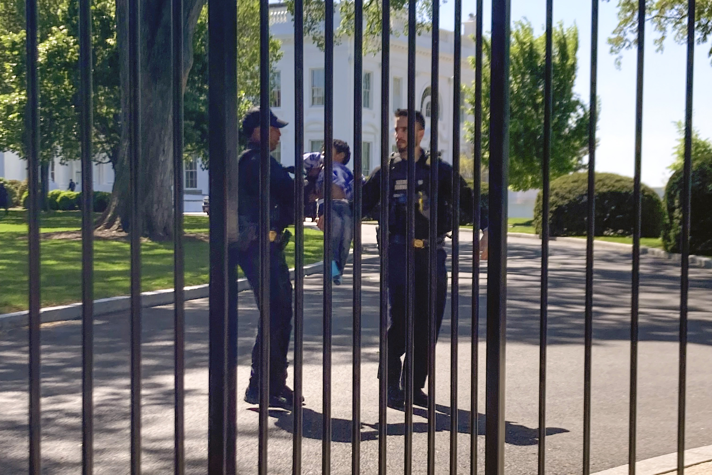 U.S. Secret Service uniformed division police officers carry a young child who crawled through the White House fence on Pennsylvania Avenue in Washington, Tuesday.