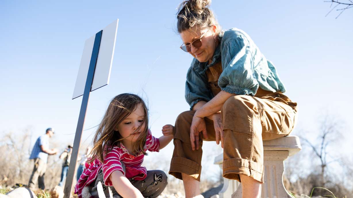 Kimberly Vanderburg-Murphy shows Lilinoe Arvin, 3, a memorial for her daughter Hali Vanderburg-Murphy at the Og-Woi People's Garden in Salt Lake City on April 10.