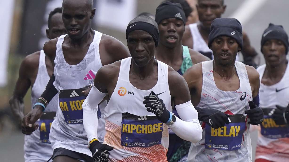 Eliud Kipchoge, of Kenya, center, runs ahead of Andualem Belay, of Ethiopia, second from right, at the front of a group of elite men, along the course of the 127th Boston Marathon, Monday, April 17, 2023, in Framingham, Mass.