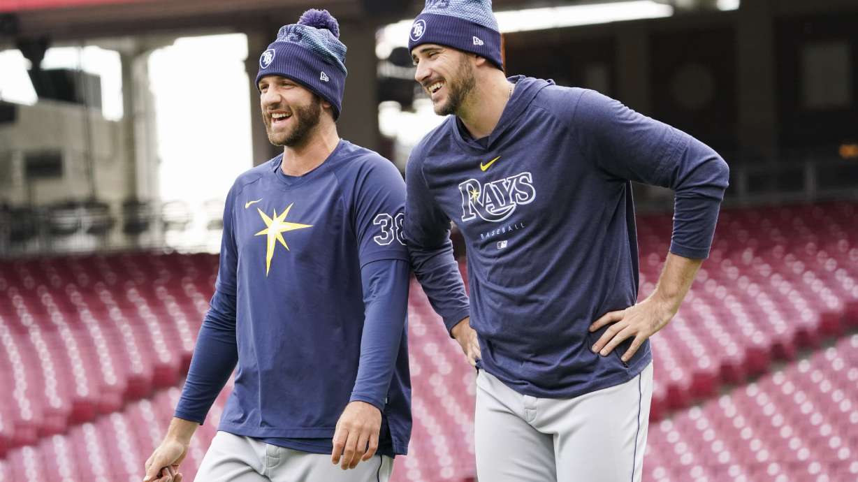 Tampa Bay Rays pitchers Colin Poche, left, and Jeffrey Springs, right, laugh during batting practice before a baseball game against the Cincinnati Reds, Monday, April 17, 2023, in Cincinnati.