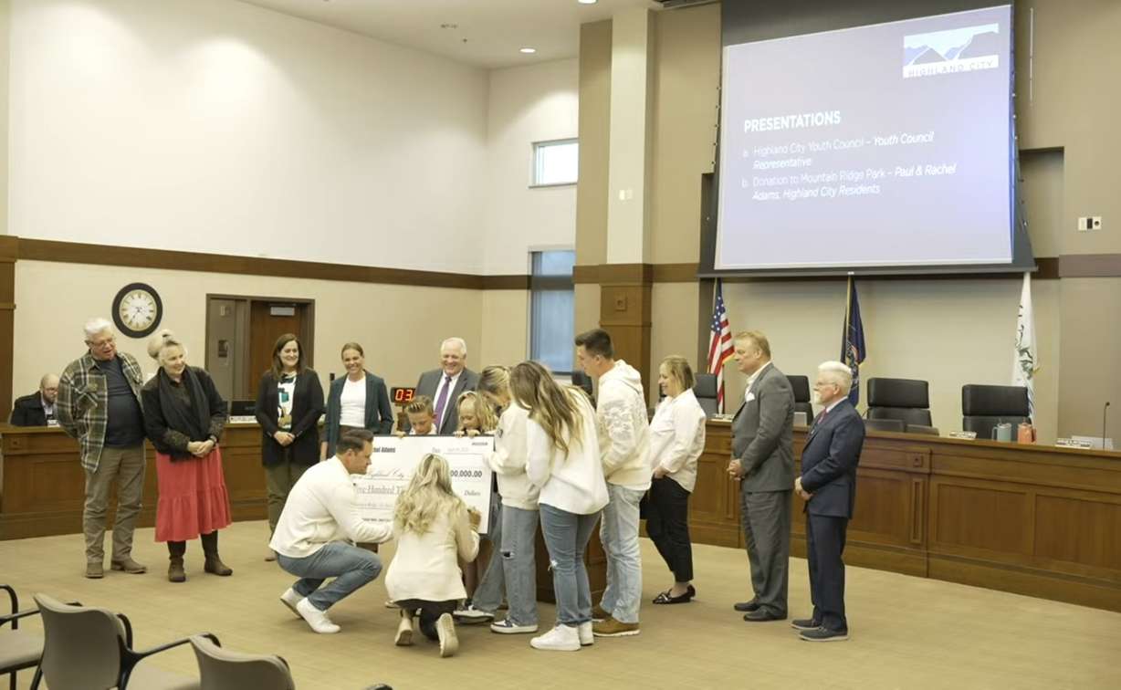 Highland residents Paul and Rachel Adams sign a $500,000 check during a Highland City Council meeting on April 18. The money is being donated to the city for an all-abilities playground to be built at Mountain Ridge Park.