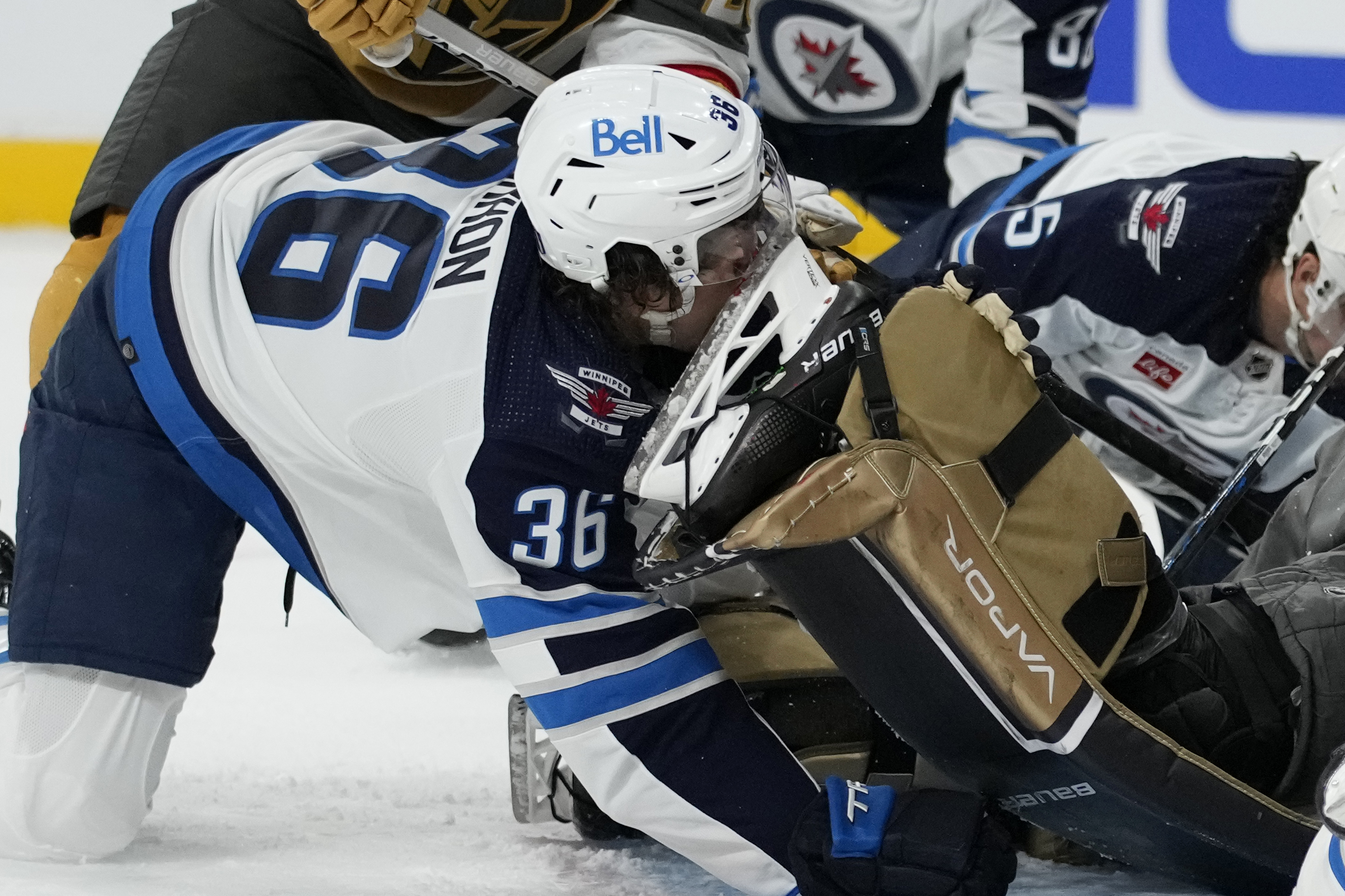 Winnipeg Jets center Morgan Barron (36) gets his face cut on the skate of Vegas Golden Knights goaltender Laurent Brossoit (39) during the first period of Game 1 of an NHL hockey Stanley Cup first-round playoff series Tuesday, April 18, 2023, in Las Vegas. 