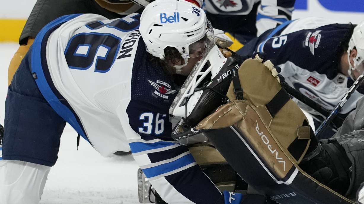 Winnipeg Jets center Morgan Barron (36) gets his face cut on the skate of Vegas Golden Knights goaltender Laurent Brossoit (39) during the first period of Game 1 of an NHL hockey Stanley Cup first-round playoff series Tuesday, April 18, 2023, in Las Vegas.