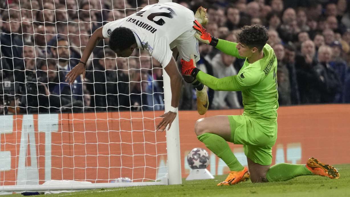 Real Madrid's Rodrygo, left, is fouled by Chelsea's goalkeeper Kepa Arrizabalaga after scoring his side's second goal during the Champions League quarterfinal second leg soccer match between Chelsea and Real Madrid at Stamford Bridge stadium in London, Tuesday, April 18, 2023.
