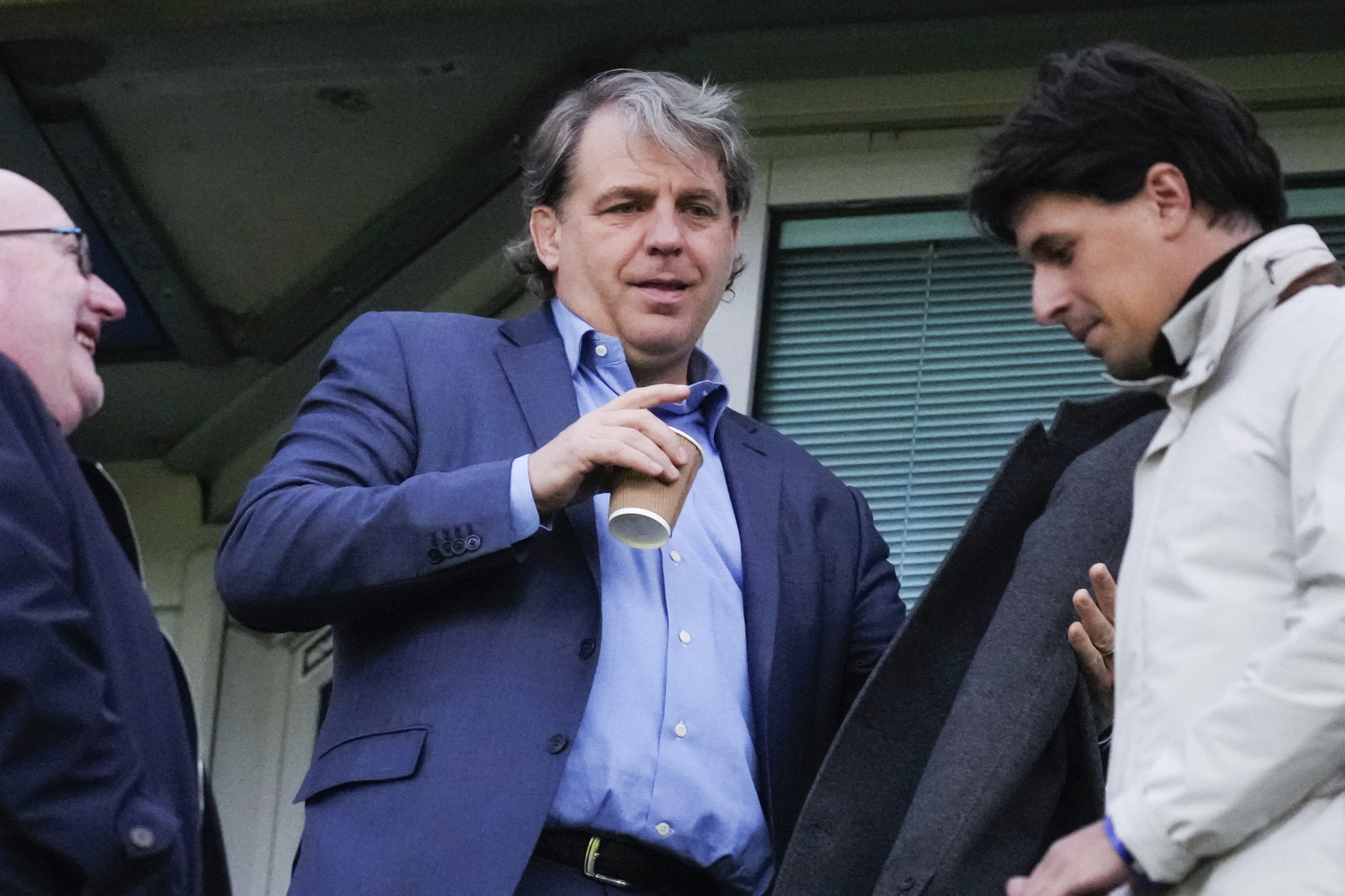 Chelsea owner Todd Boehly, centre, waits for the start of the Champions League quarterfinal second leg soccer match between Chelsea and Real Madrid at Stamford Bridge stadium in London, Tuesday, April 18, 2023. 