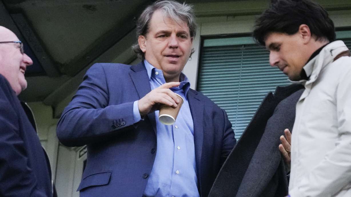 Chelsea owner Todd Boehly, centre, waits for the start of the Champions League quarterfinal second leg soccer match between Chelsea and Real Madrid at Stamford Bridge stadium in London, Tuesday, April 18, 2023.