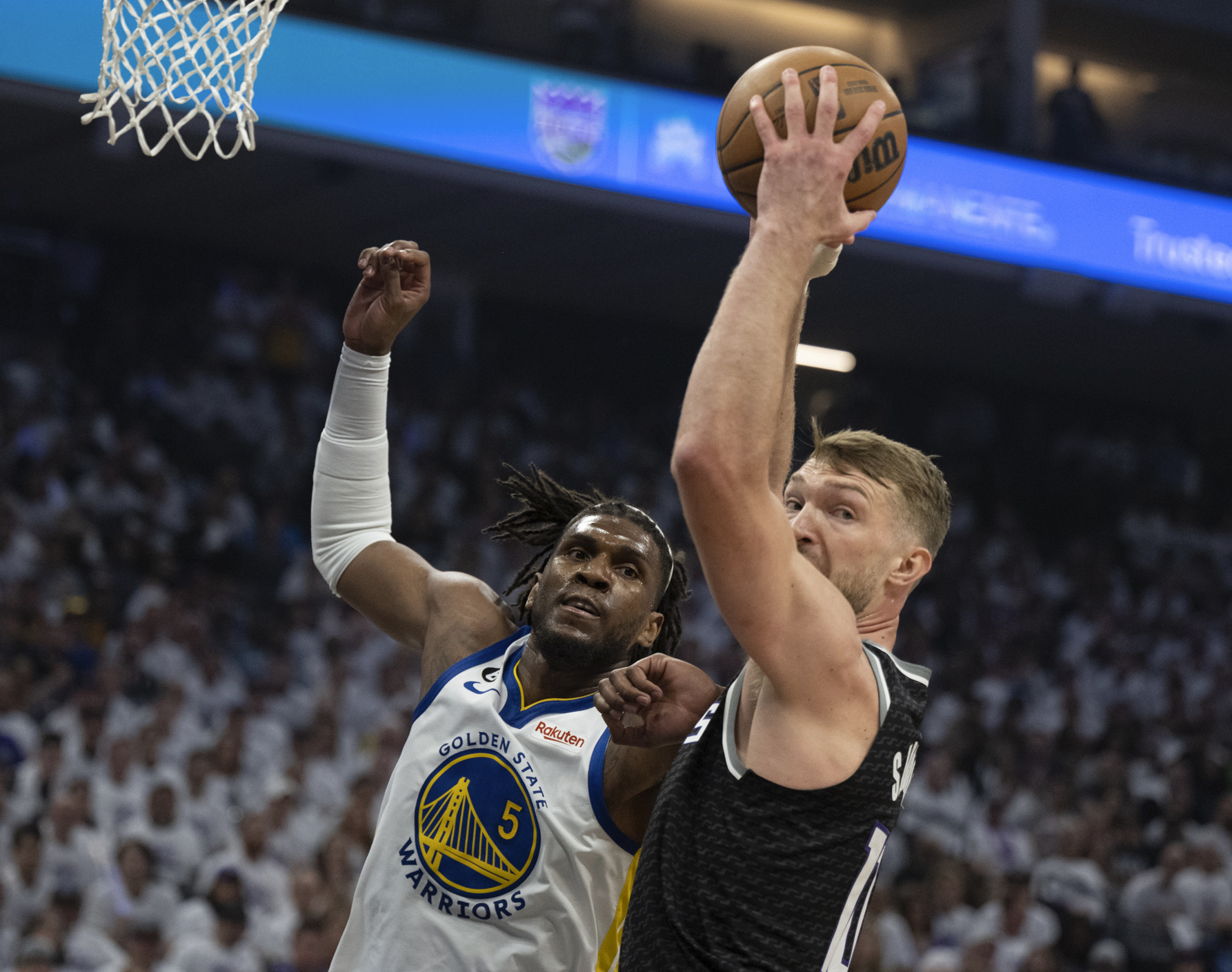 Sacramento Kings forward Domantas Sabonis, right, grabs a rebound against Golden State Warriors forward Kevon Looney, left, in the first quarter during Game 1 in the first round of the NBA basketball playoffs in Sacramento, Calif., Saturday, April 15, 2023. 
