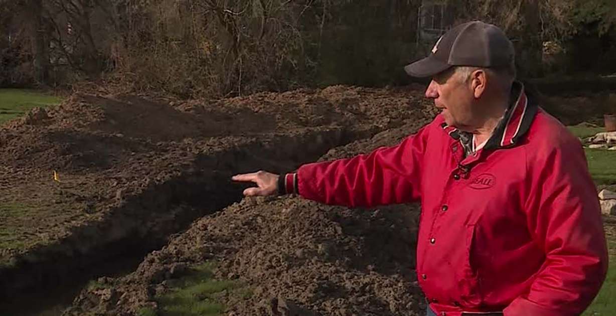 Bob Taggart points out a trench dug in his yard to keep water away from the foundation of his house Wednesday. Underground spring water has flooded at least 17 North Ogden homes.