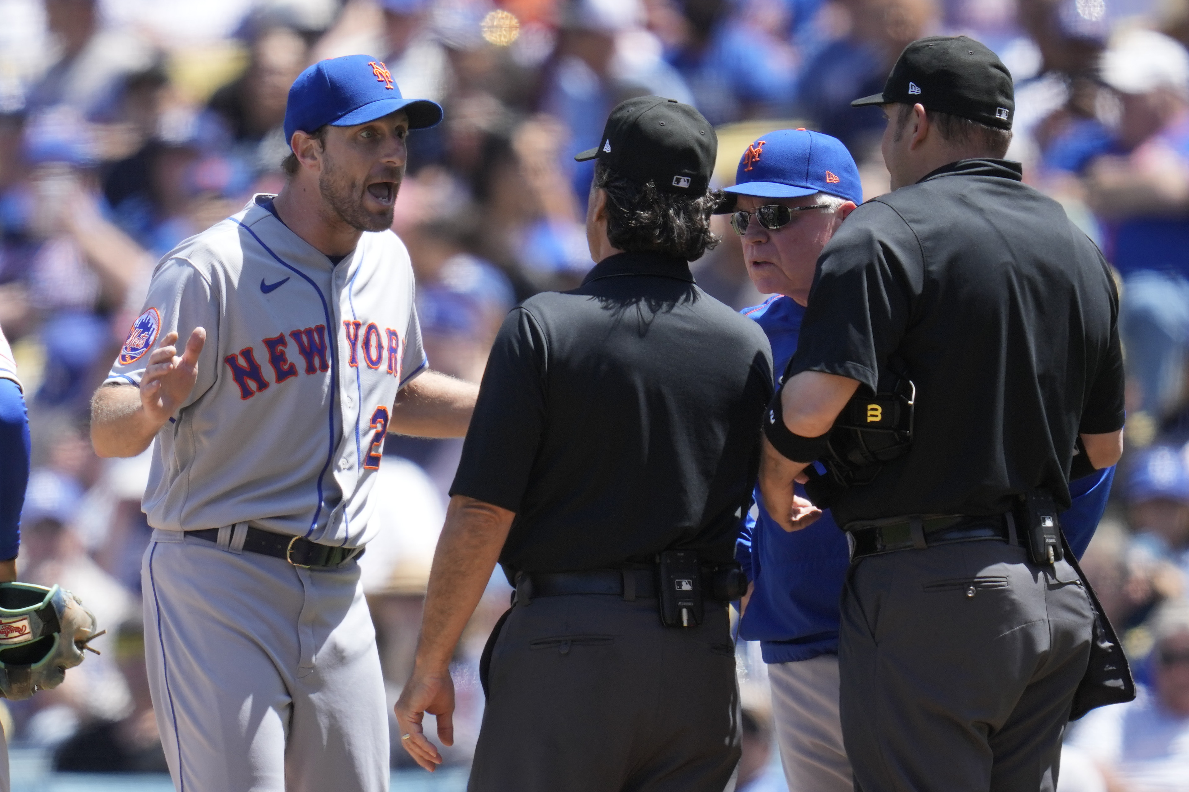 New York Mets starting pitcher Max Scherzer (21) and manager Buck Showalter dispute a call from umpire Phil Cuzzi, center, and umpire Dan Bellino, right, after they found a problem with Scherzer's glove during the fourth inning of a baseball game in Los Angeles, Wednesday, April 19, 2023. Scherzer was ejected from the game.